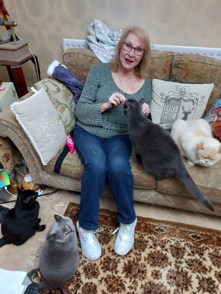 Clairissa surrounded by four of her cats.